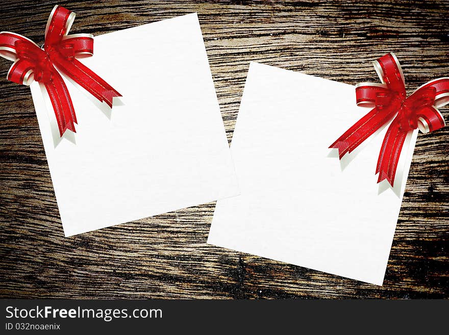 Red ribbon satin gift bow on wood background