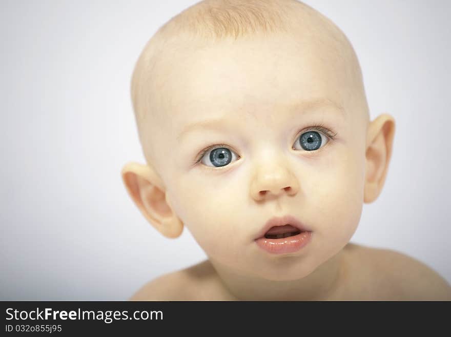 12 month old baby looks astonished at the camera. 12 month old baby looks astonished at the camera