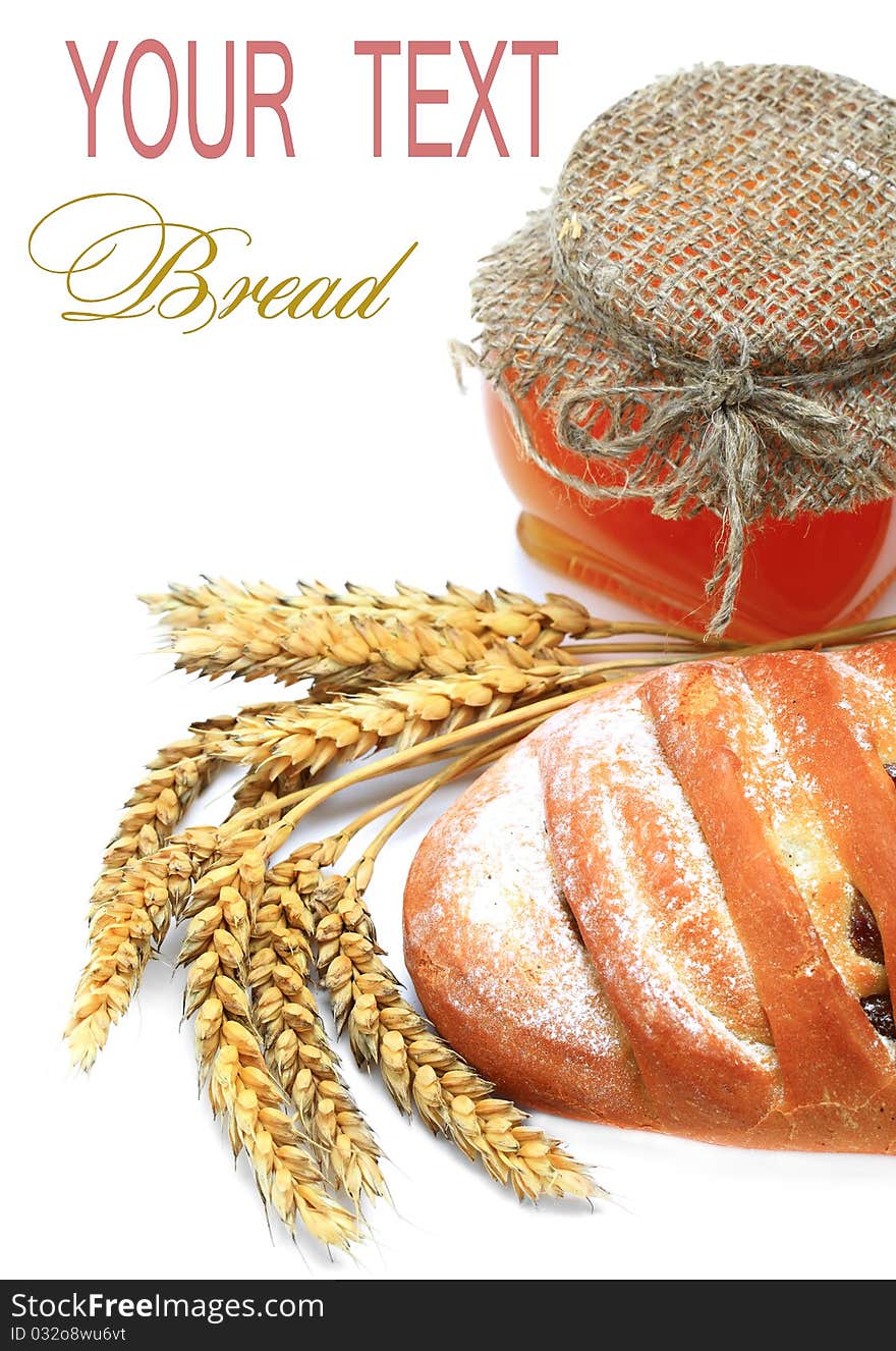 Wheat bread, honey and spikelets on a white background. Wheat bread, honey and spikelets on a white background