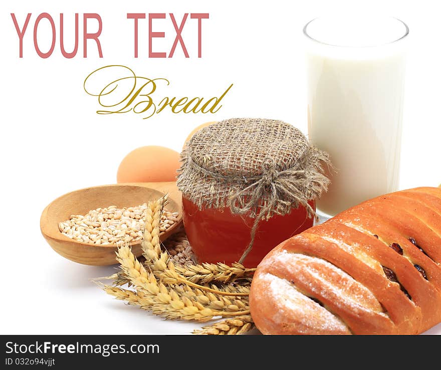 Wheat bread, honey and spikelets on a white background. Wheat bread, honey and spikelets on a white background