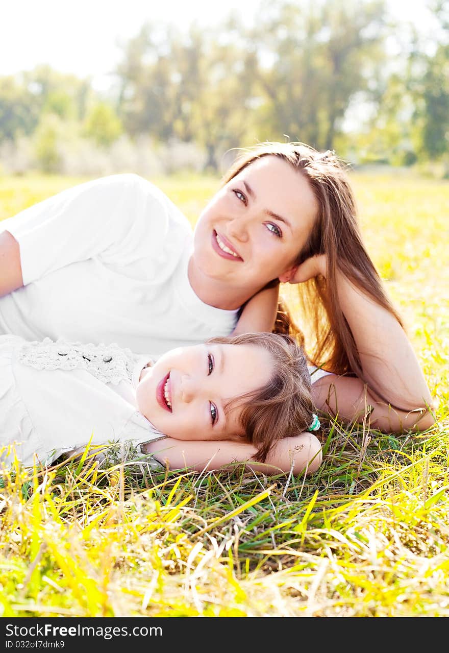 Young mother and her daughter in the park on a sunny autumn day (focus on the child). Young mother and her daughter in the park on a sunny autumn day (focus on the child)