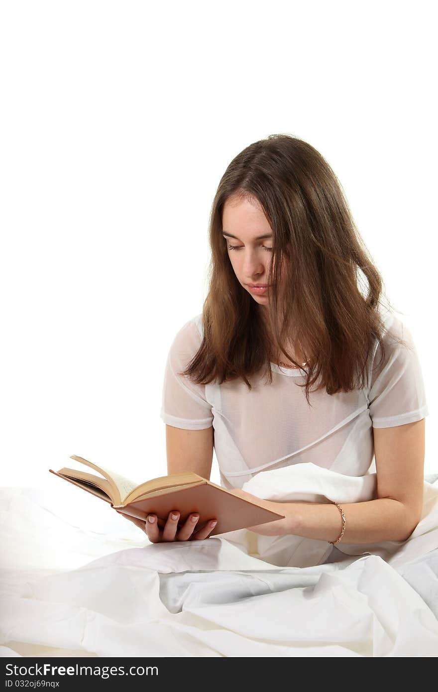 Young woman sit in a bed and read book. Young woman sit in a bed and read book