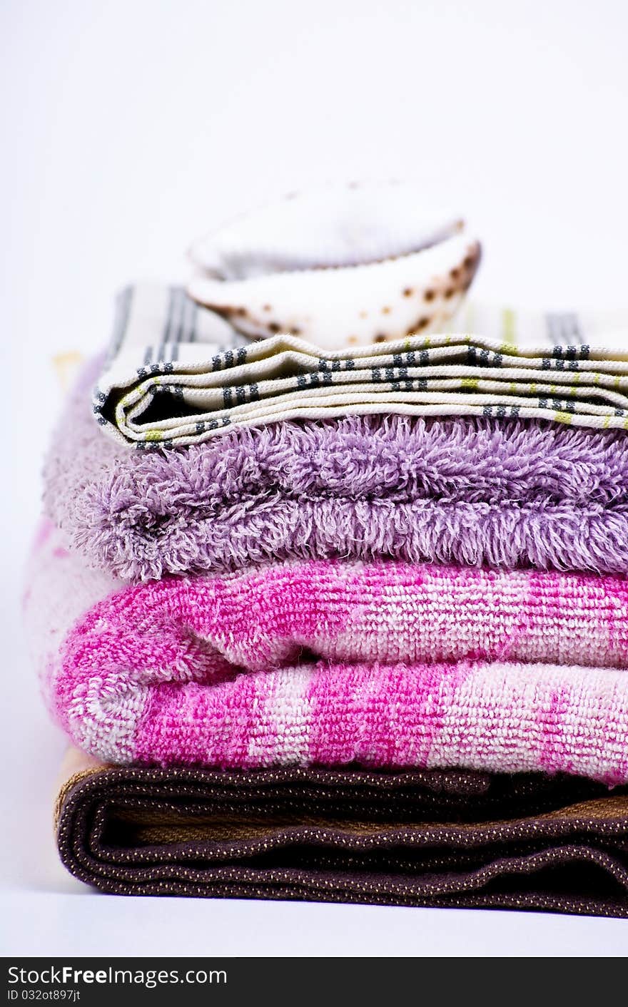 Closeup of colorful bath towels and sea shell