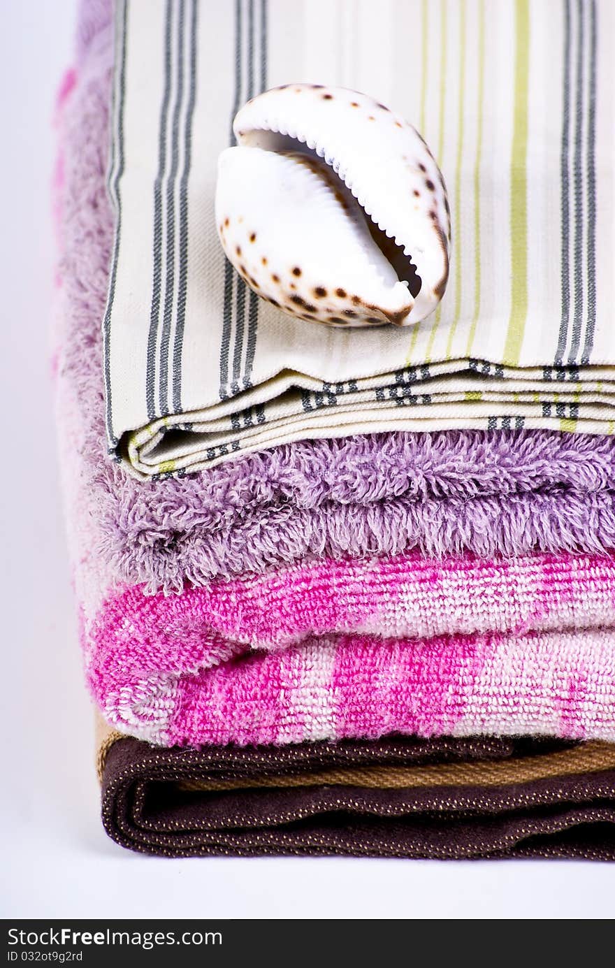 Closeup of colorful bath towels and sea shell