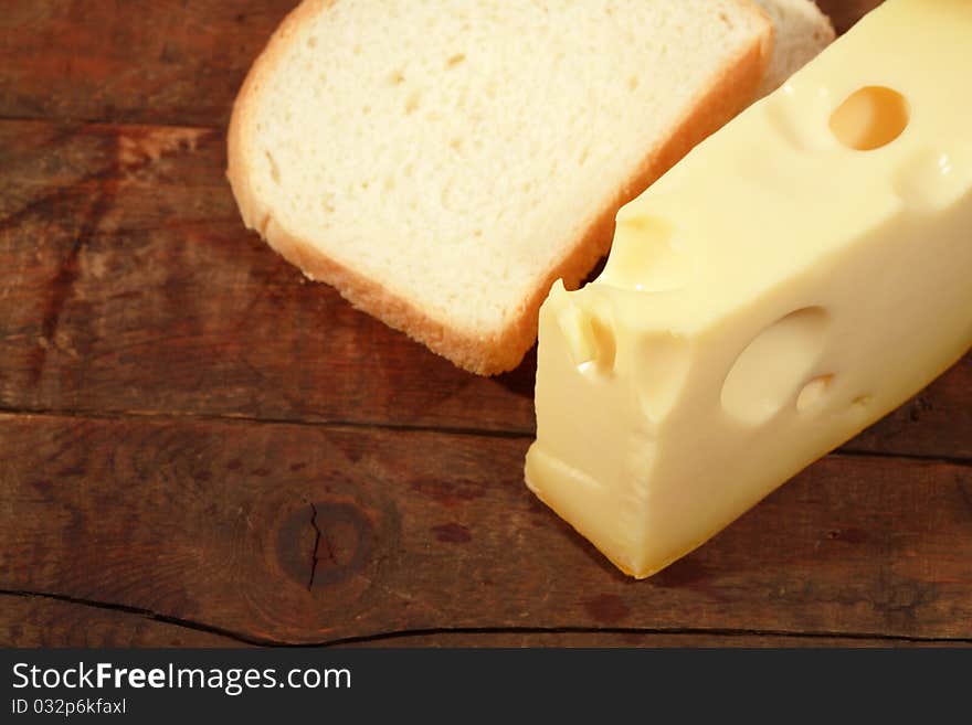 Closeup of cheese and white bread on wooden background. Closeup of cheese and white bread on wooden background