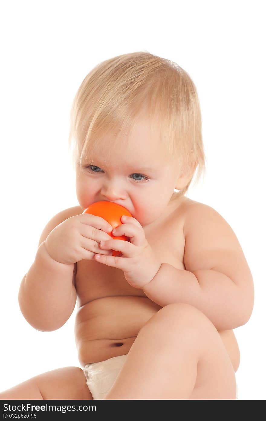 Portrait of angry young sitting baby bitting orange ball