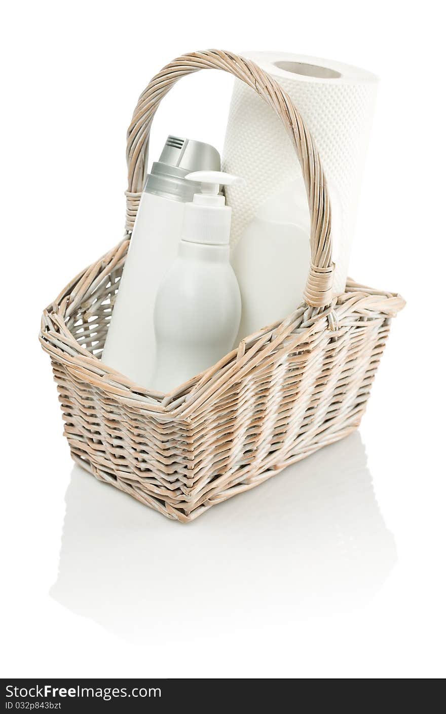 Basket with bottles and paper towel isolated on white