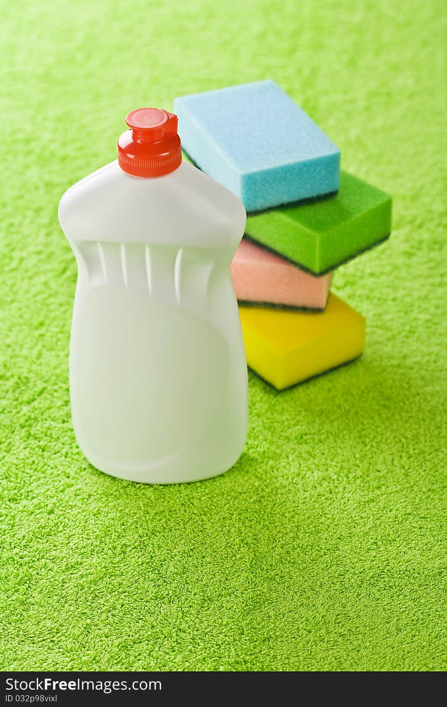 Bottle and sponges on a background of a green towel. Bottle and sponges on a background of a green towel