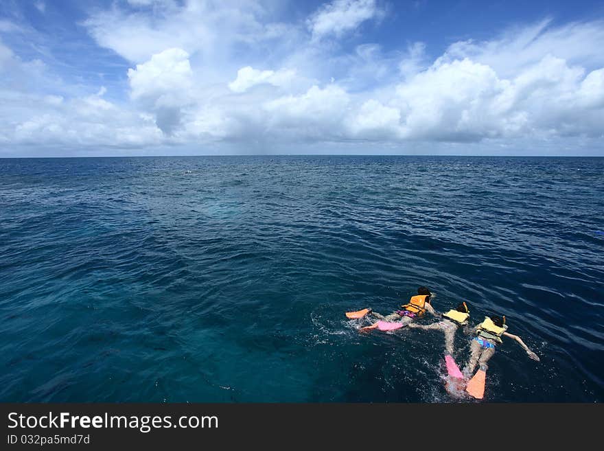 Three people snorkeling in the Great Barrier Reef