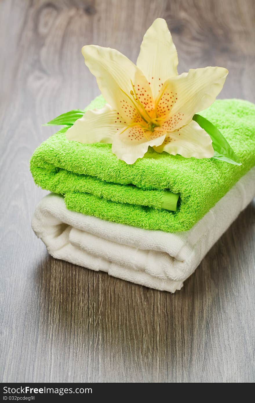 Flower on two green and white towels on wooden background. Flower on two green and white towels on wooden background