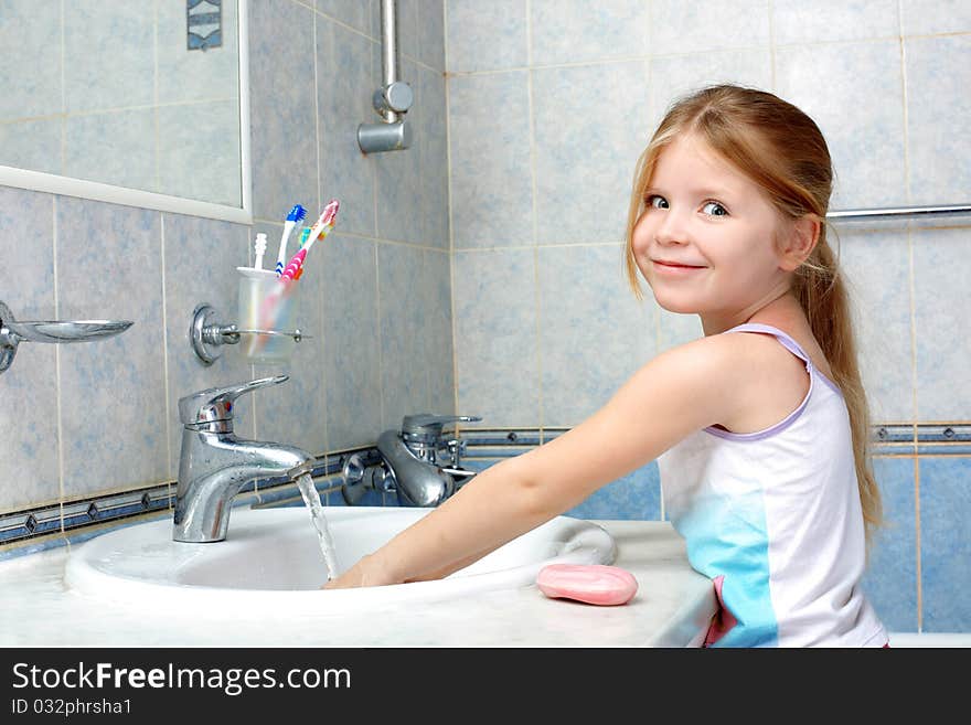 Little girl washing in bathroom