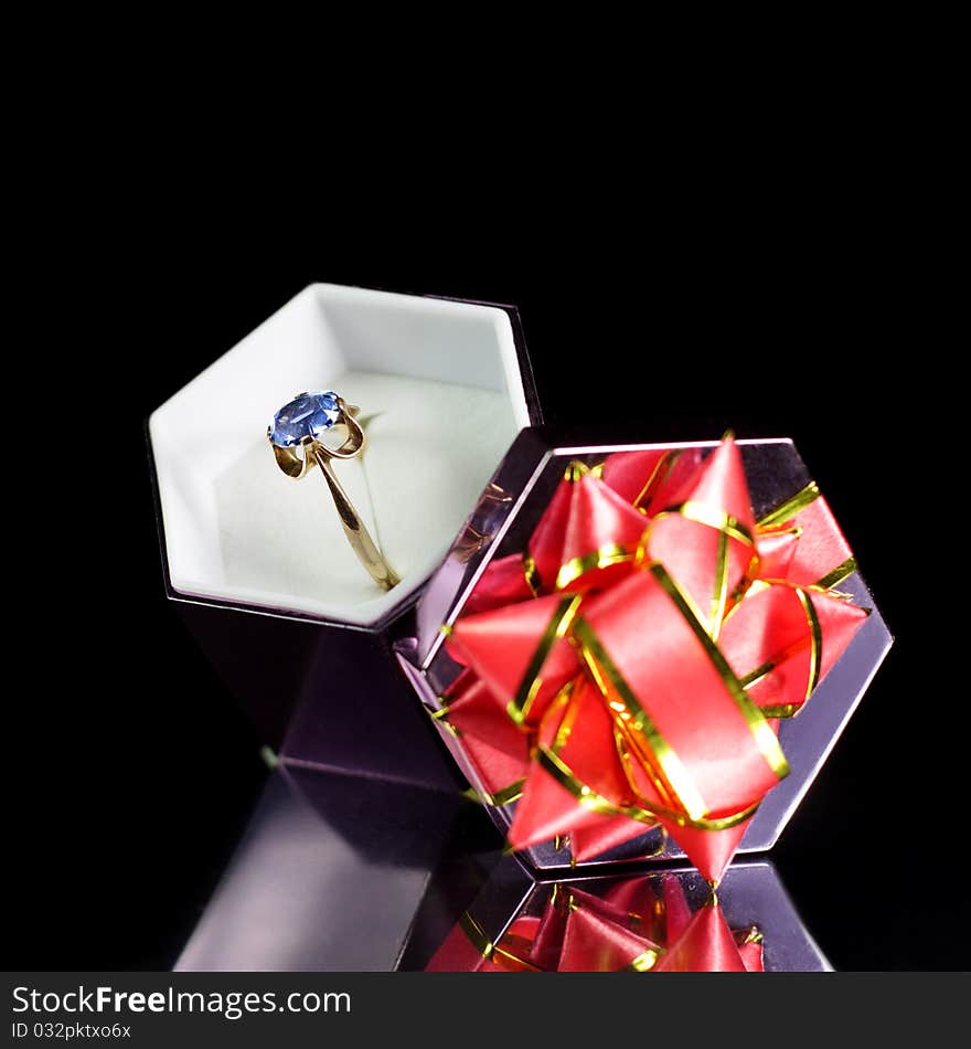 Gold ring in a gift box on a black background