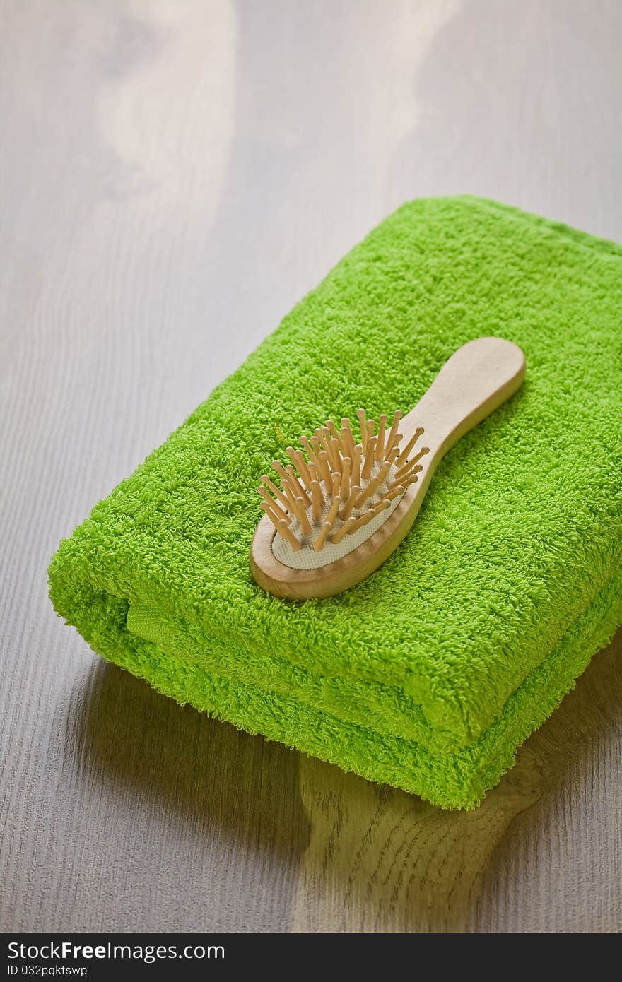 Green towel with hairbrush