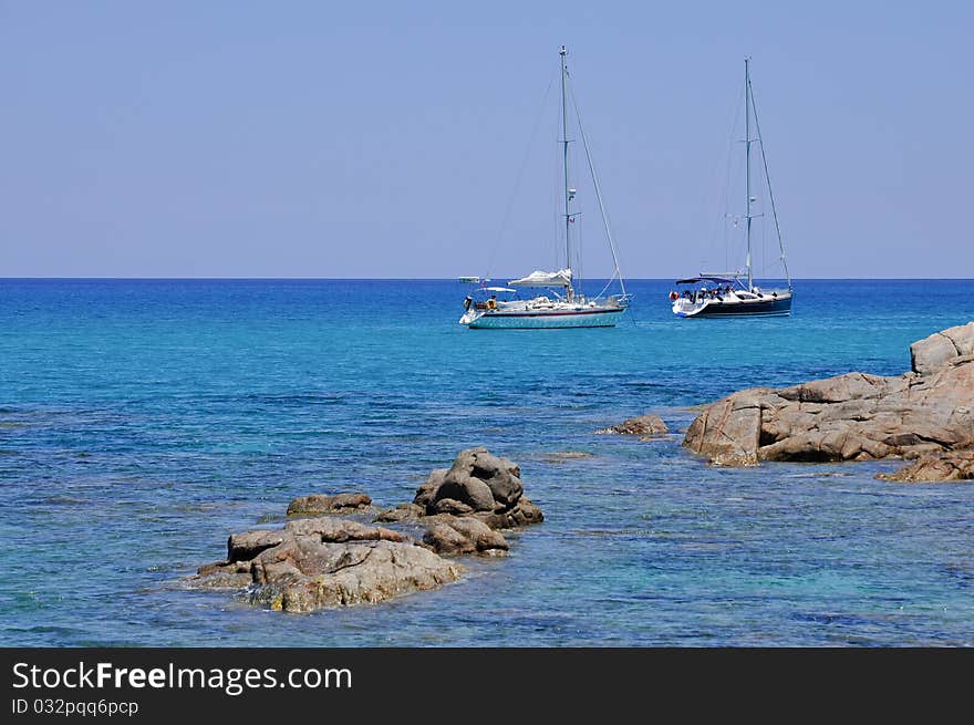 Sailboats moored in the beautiful sea of Porto Giunco, Villasimius, in Sardinia, Italy. Sailboats moored in the beautiful sea of Porto Giunco, Villasimius, in Sardinia, Italy.