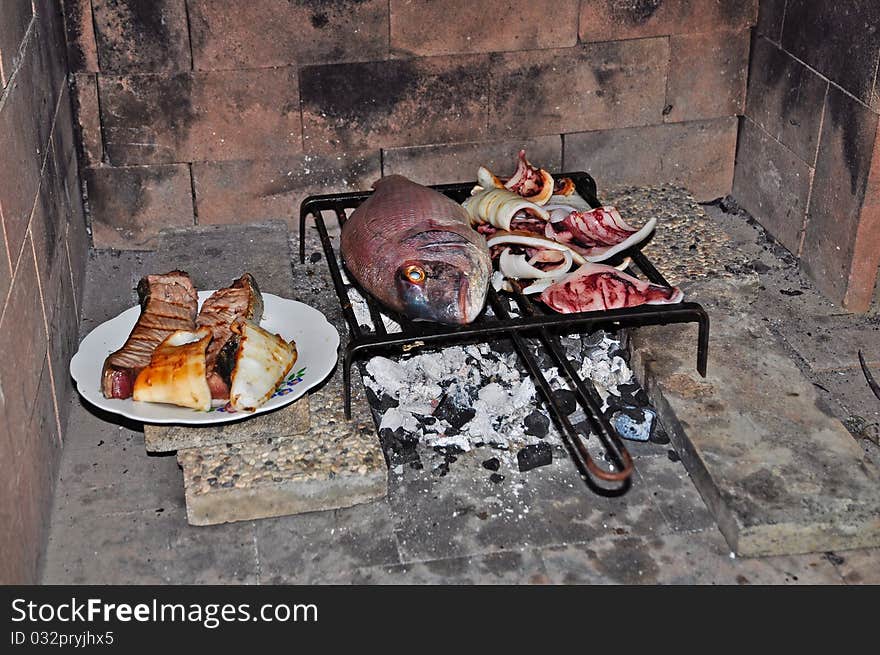 Fish and meat cooking on the grill