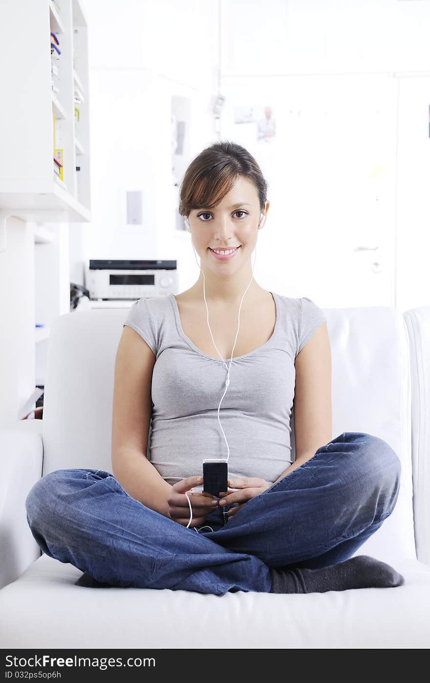 Young woman listening music in home interior