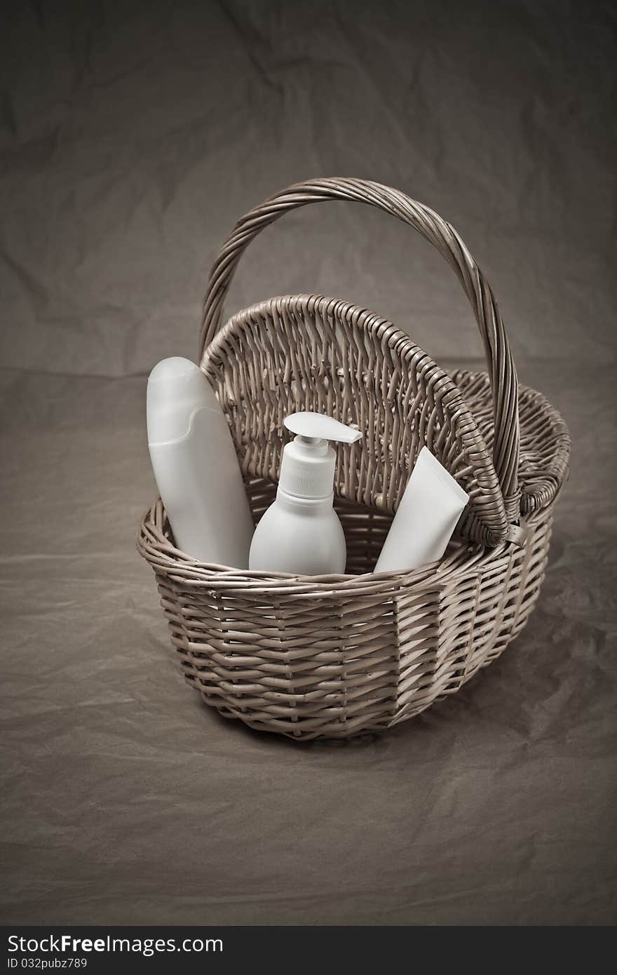 Basket with bottles and tube on paper background