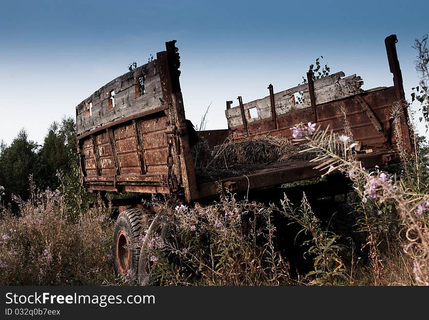 Abandoned old tractor trailer, in the field of overgrown grasses