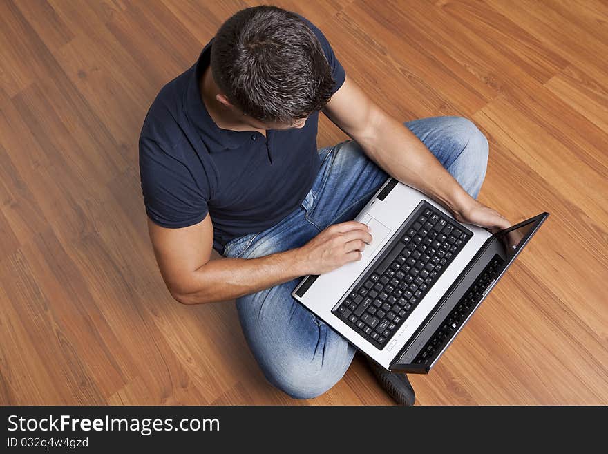 Man sitting on the floor working on laptop