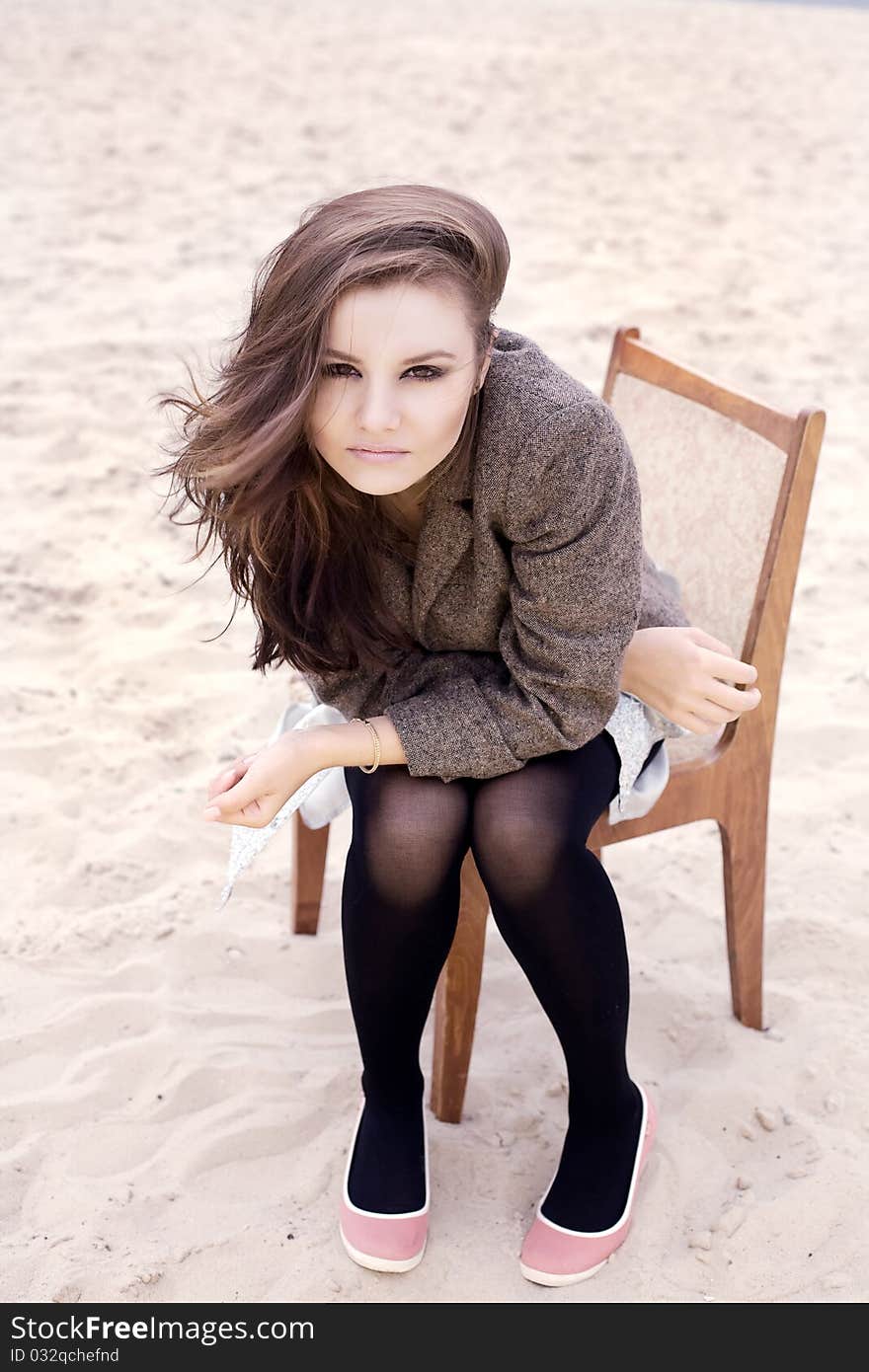 Sexy brunette woman with make up sitting on a chair on beach. Sexy brunette woman with make up sitting on a chair on beach