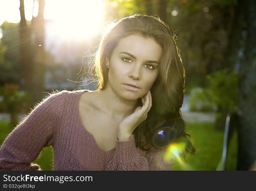 A portrait of beautiful brunett girl is in the sun forest