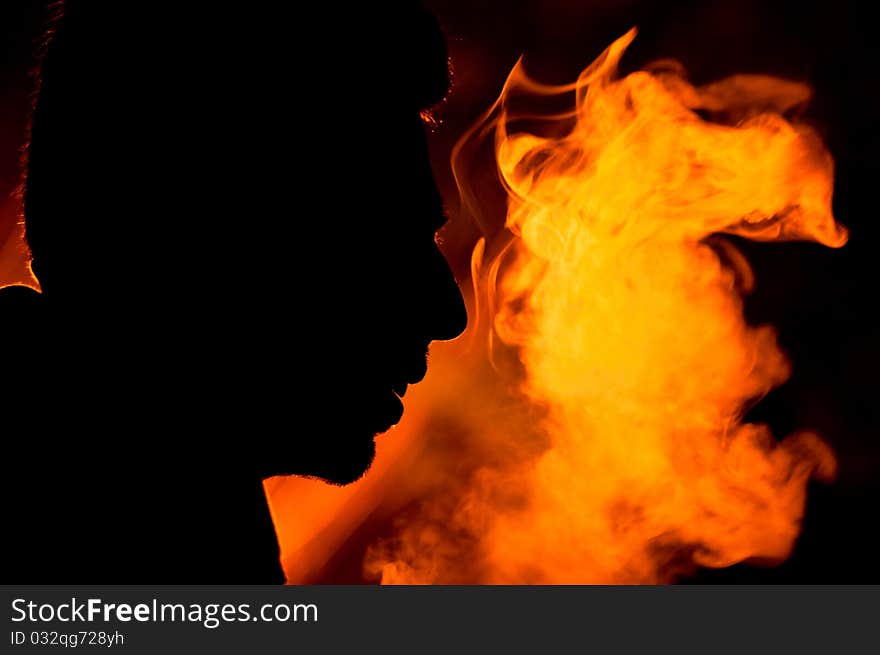 Silhouette of a man's face just next to the illuminated smoke that he had exhaled. Portraying power and dynamism. Silhouette of a man's face just next to the illuminated smoke that he had exhaled. Portraying power and dynamism.