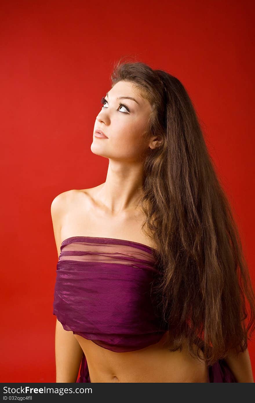 Beauty woman in transparent veil on red background