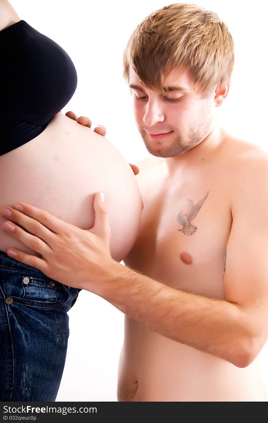 A young man looking at his mates pregnant belly. A young man looking at his mates pregnant belly.