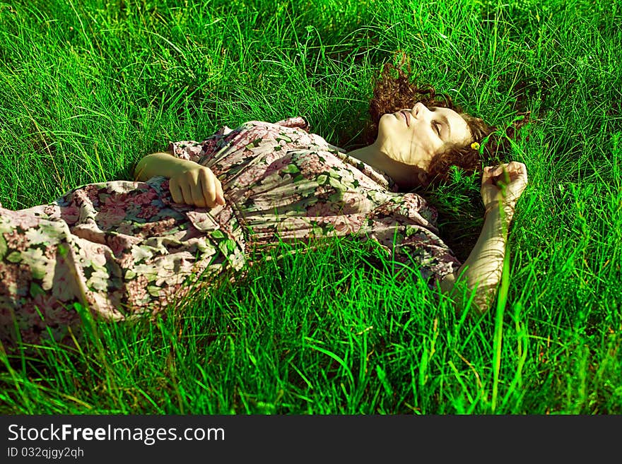 A beautiful girl lies in a green grass