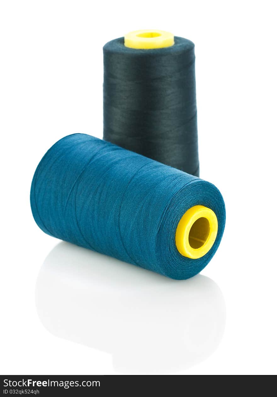 Blue and black threads on spools isolated on white background
