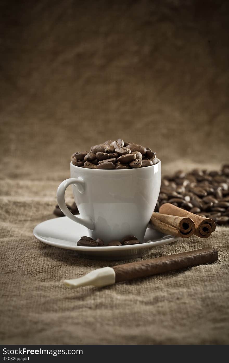 Cup with coffee beans and cinnamon