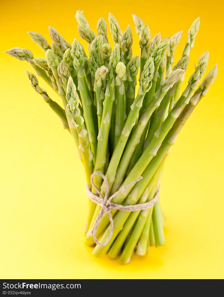 Sheaf of asparagus on a yellow.