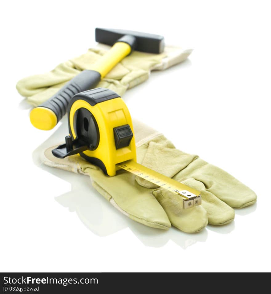 Gloves with measuring tape and hammer isolated on white background