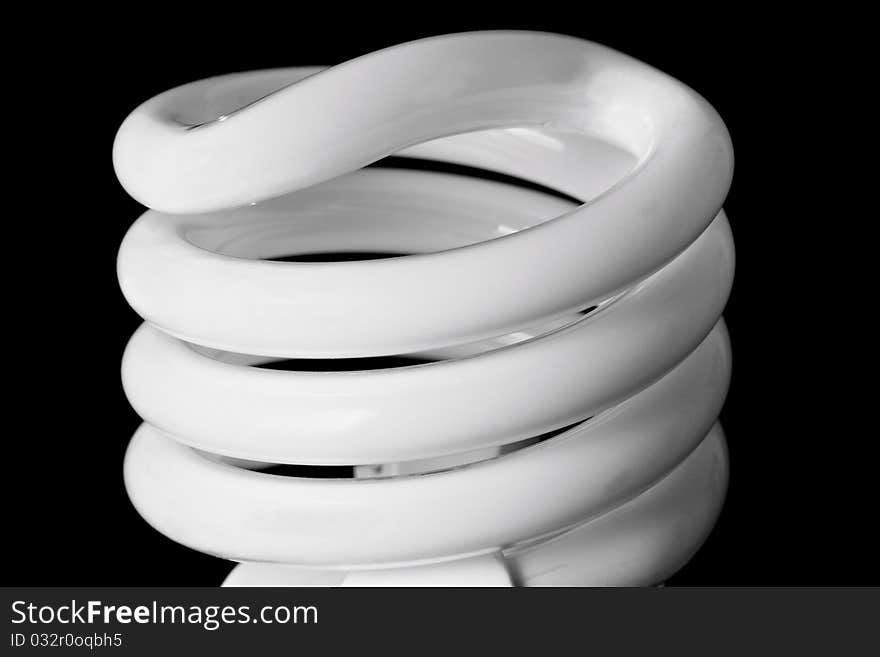 Close up of a compact fluorescent light bulb against a black background