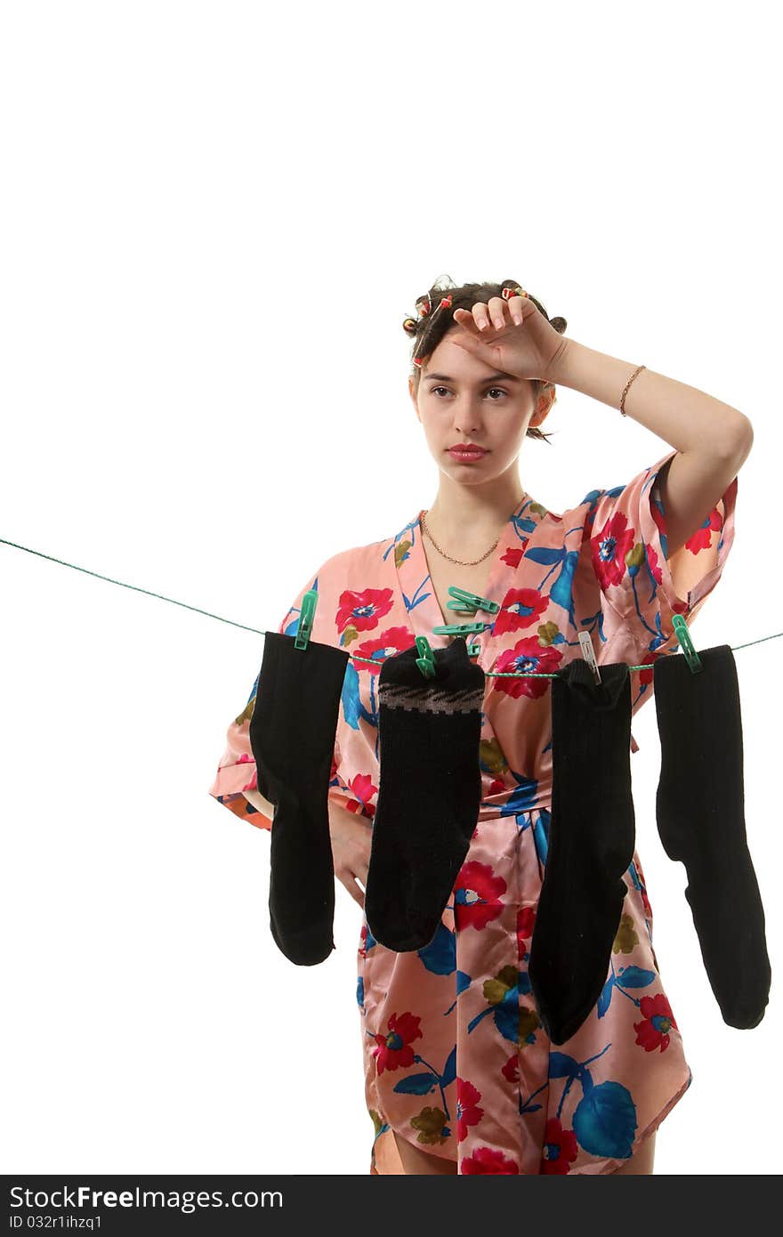 Young tired housewife hangs up socks on the clothesline. Young tired housewife hangs up socks on the clothesline