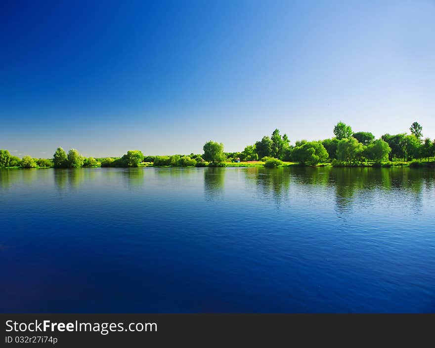 Horizontal image
viw on water of river
and green bush and trees
and contrast blue sky
with reflection of all it. Horizontal image
viw on water of river
and green bush and trees
and contrast blue sky
with reflection of all it