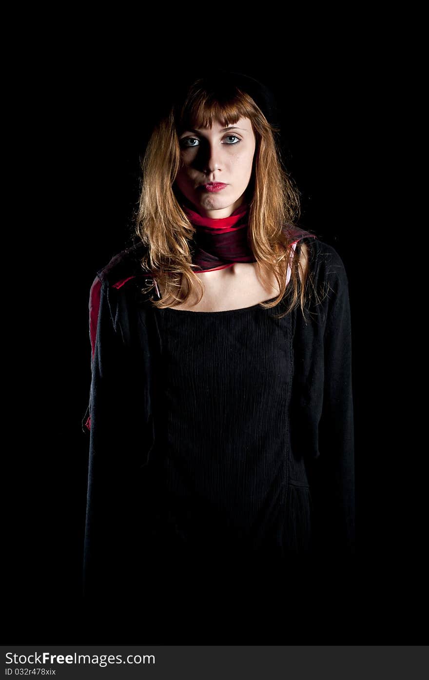 Dark girl with hat and red scarf on black background