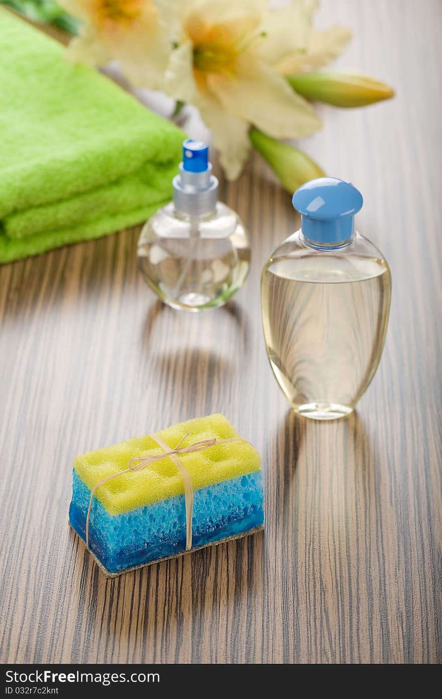 Group of bath articles and flower on wooden background