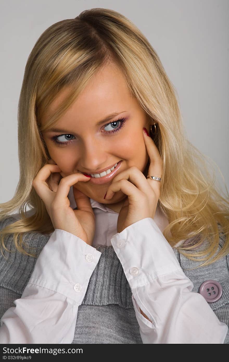 Portrait of the young beautiful smiling girl on a grey background