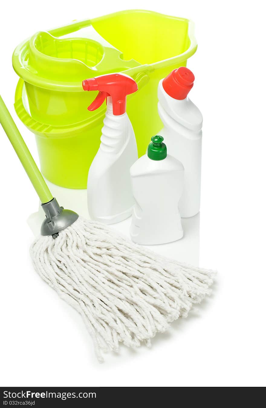 Plastical green bucket with mop and kitchen cleaners with olored lids and spray isolated on white background with reflection on white blurry background. Plastical green bucket with mop and kitchen cleaners with olored lids and spray isolated on white background with reflection on white blurry background