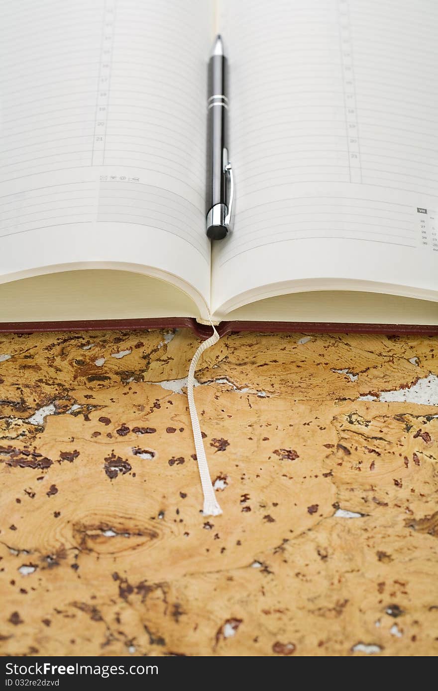 Pen and diary on cork wood