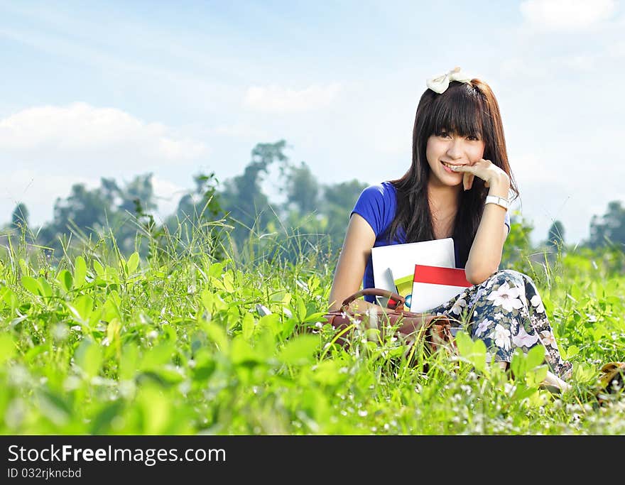 Portrait of young beautiful girl smiling with many books in her hand in beautiful sunny day. Portrait of young beautiful girl smiling with many books in her hand in beautiful sunny day