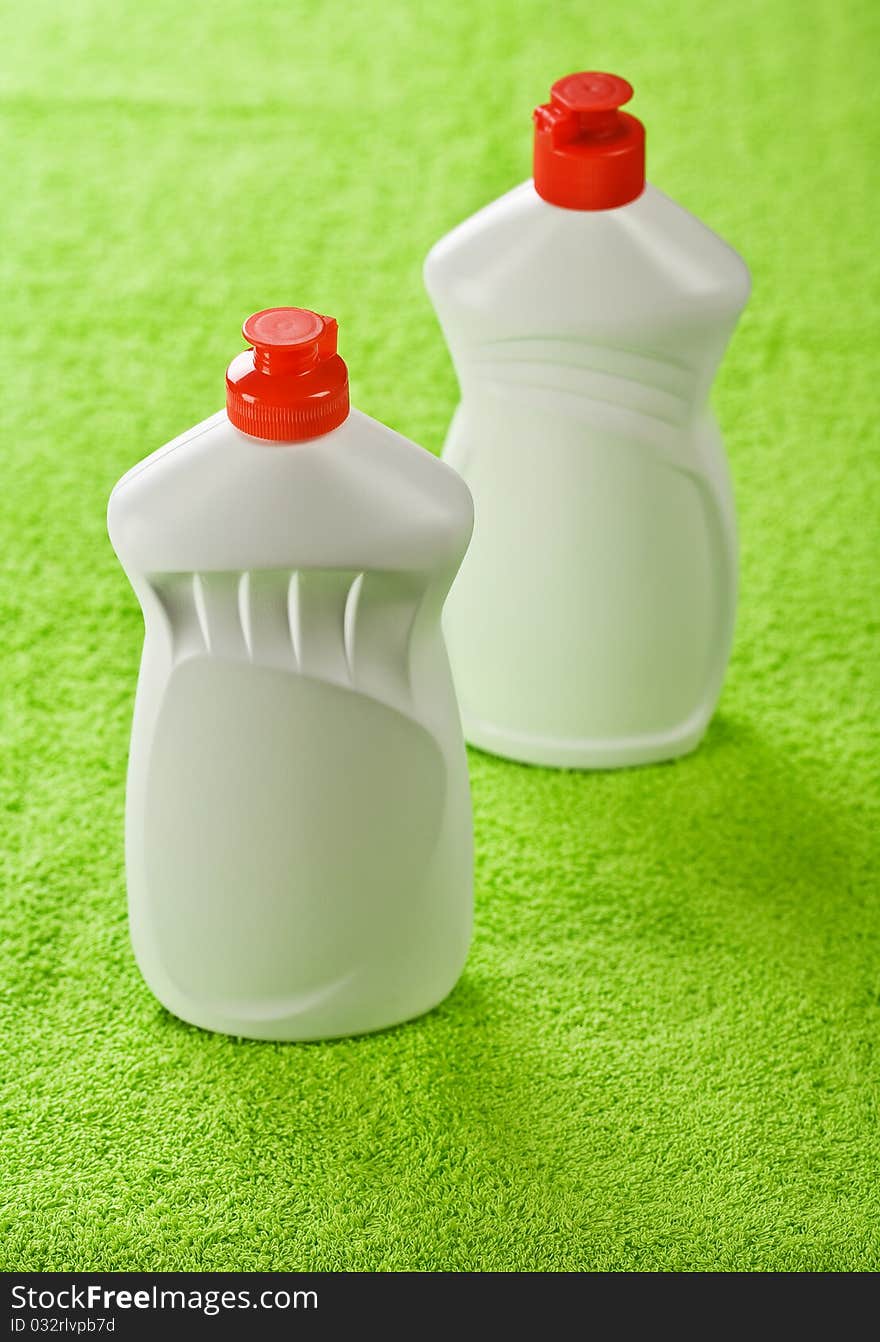 Two plastic bottles on green towel