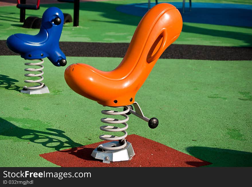 Empty blue and orange seesaws on a playground