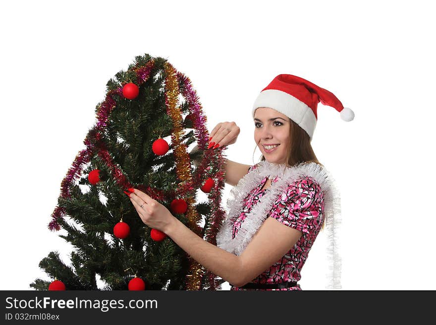 Woman in a christmas hat decorate a christmas tree. Woman in a christmas hat decorate a christmas tree