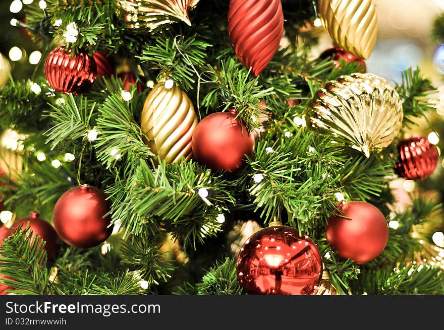 Red Christmas decorations and lights on a green tree