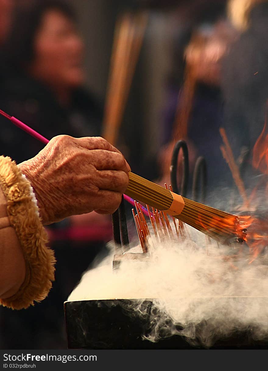 An old woman Pray at censer front in yonghegong temple. An old woman Pray at censer front in yonghegong temple