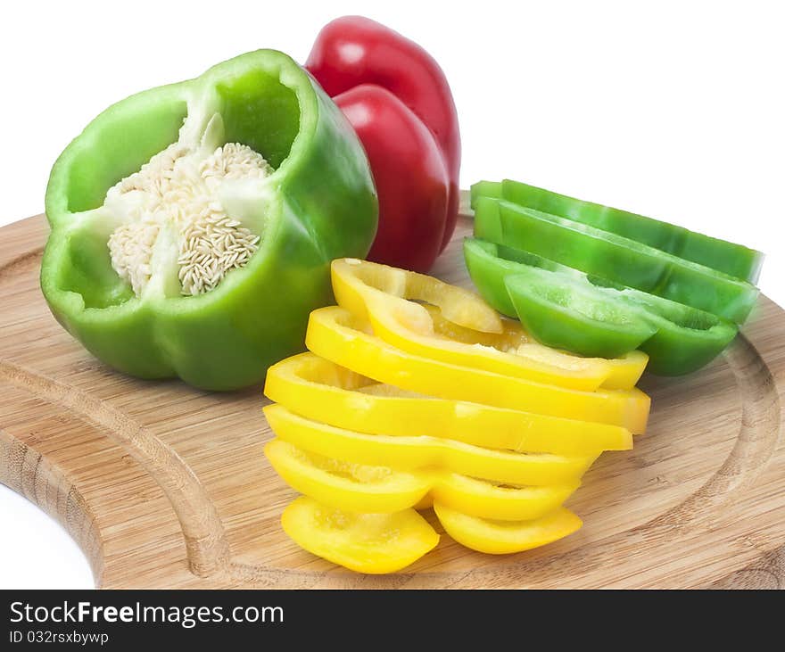 Colorful bell peppers, cut into slices on a wooden board