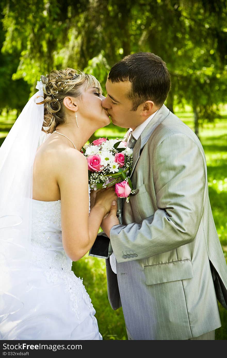 Two newlywed kisses in green park. Two newlywed kisses in green park