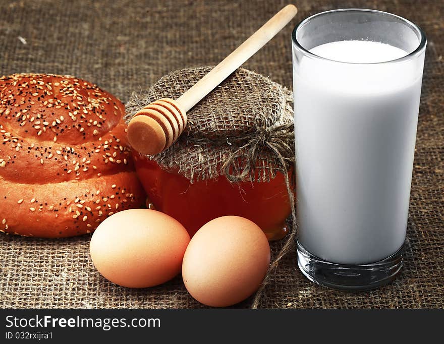 Wheat bread, honey and spikelets with eggs in sackcloth. Wheat bread, honey and spikelets with eggs in sackcloth